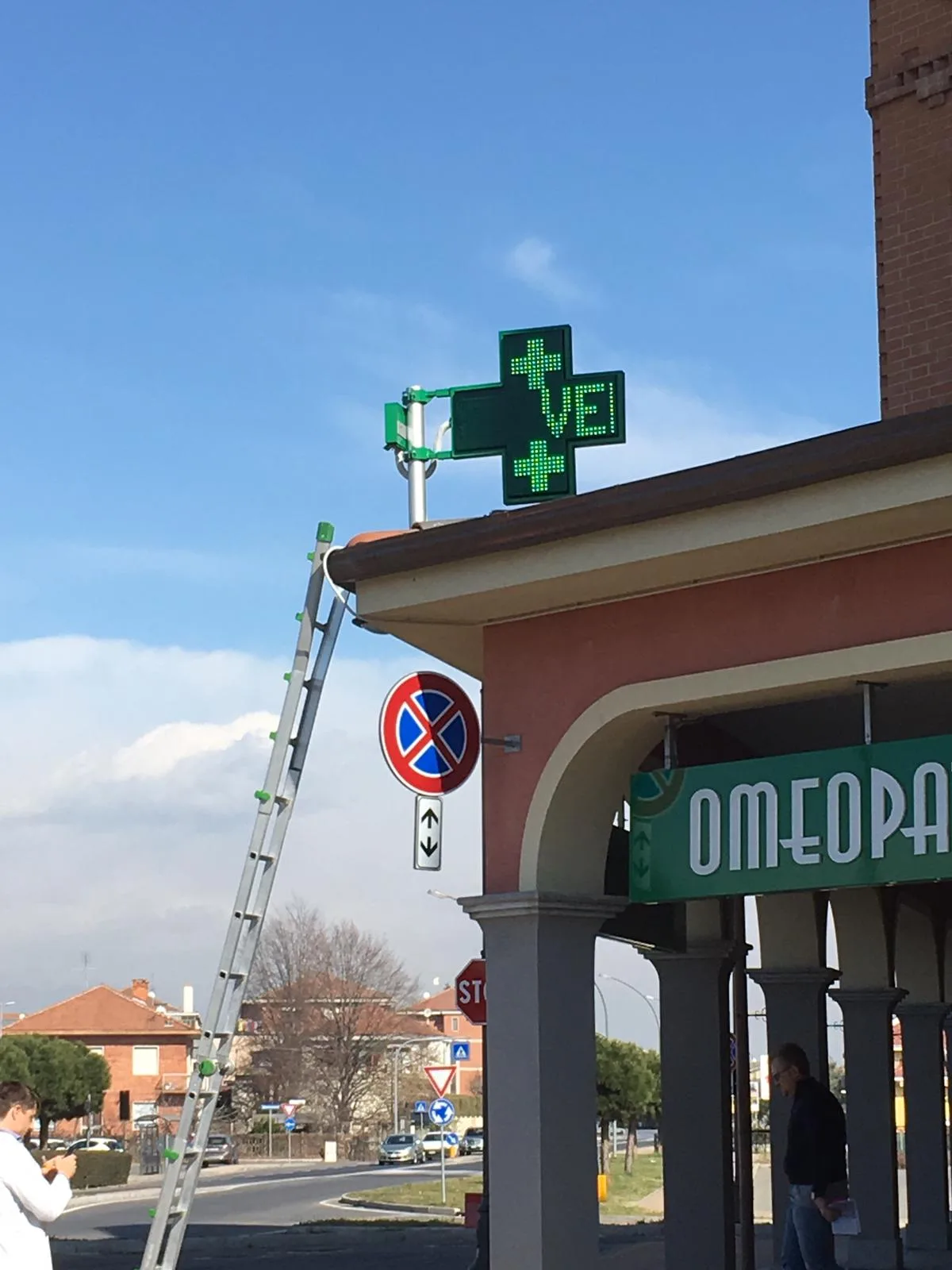 Croce verde luminosa a led appena installata sull'angolo di una farmacia