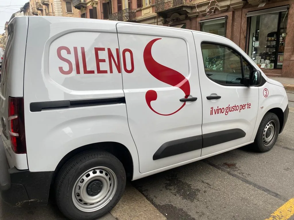 Furgone bianco di un'enoteca allestito con il logo rosso e lo slogan sulla fiancata