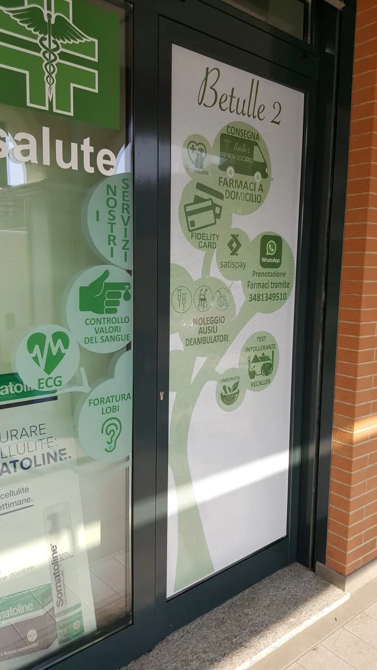 Porta di una farmacia allestita con vetrofania illustrata ad albero con i servizi offerti