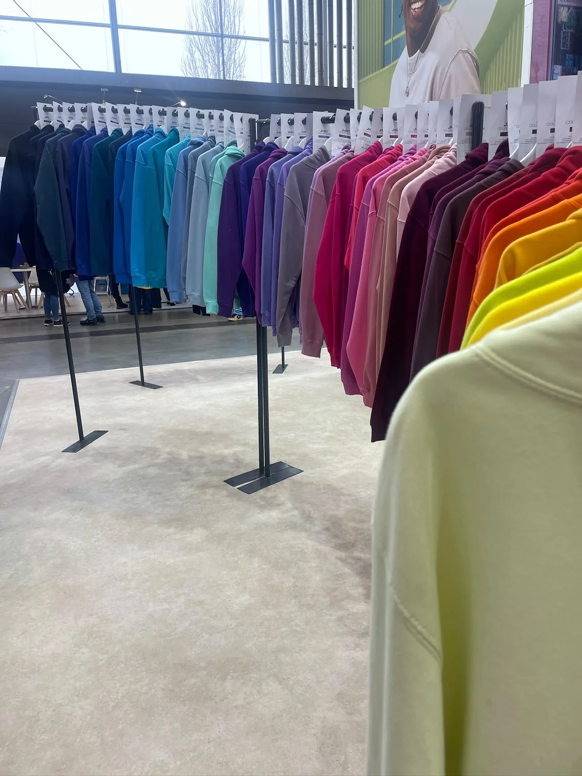 Felpe di tanti colori appese in fila su un espositore