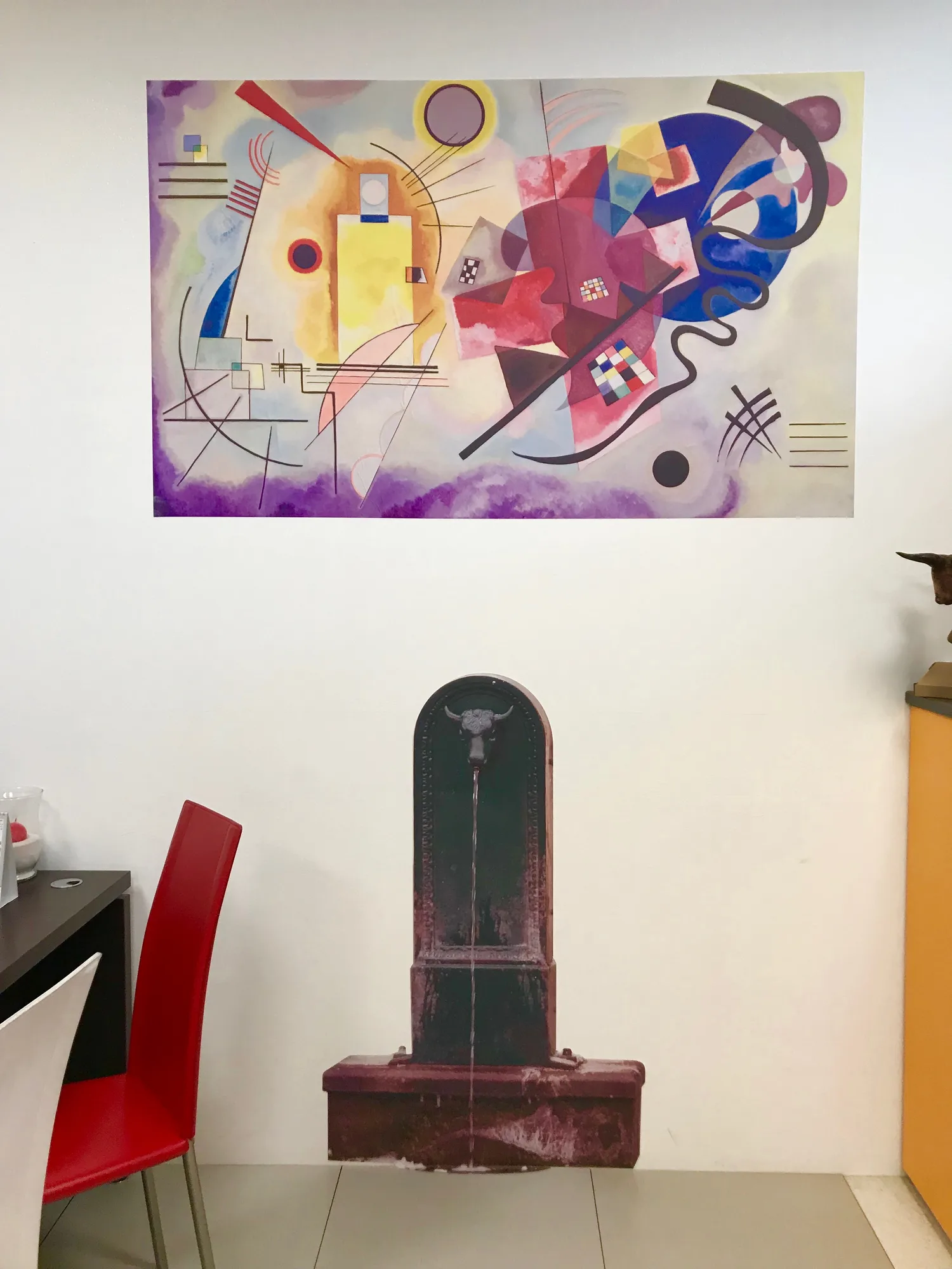 Parete con riproduzione di un quadro astratto e sagoma adesiva di una fontanella torinese col toret