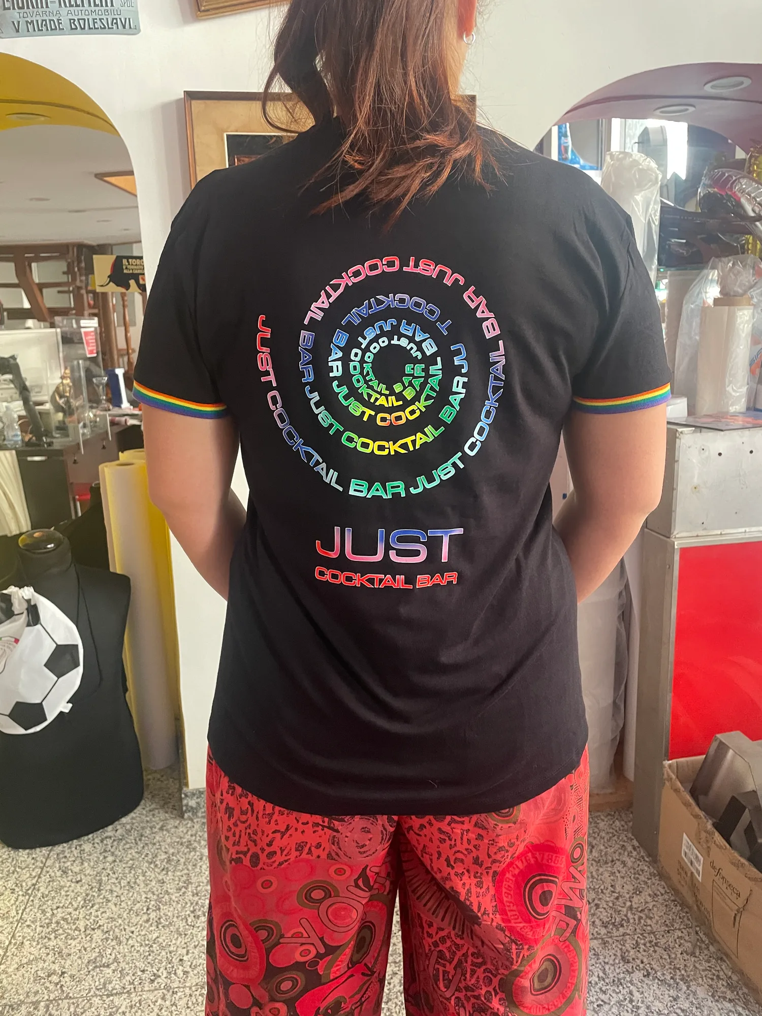 Retro di una t-shirt nera per un cocktail bar con scritta a spirale stampata in colori sfumati