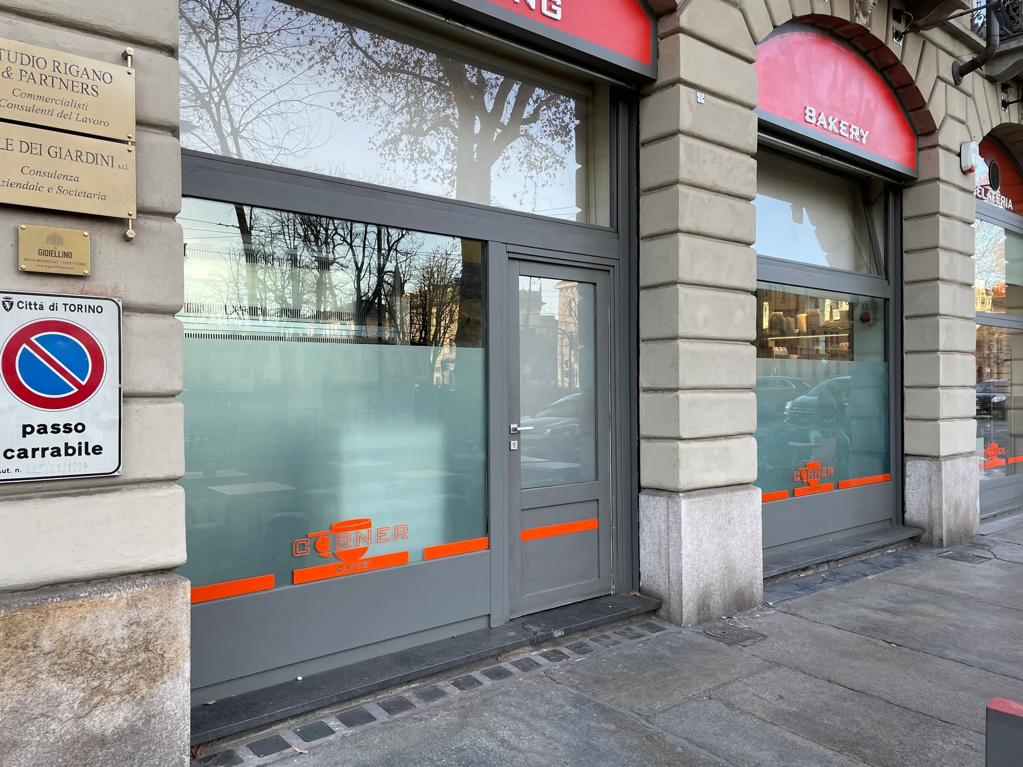 Vetrine di un bar con pellicola satinata, fasce arancioni e logo in plexiglass sagomato applicato