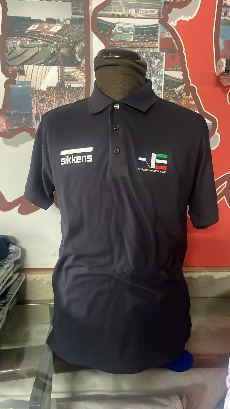 Polo blu scuro personalizzata con due loghi stampati sul petto, su manichino