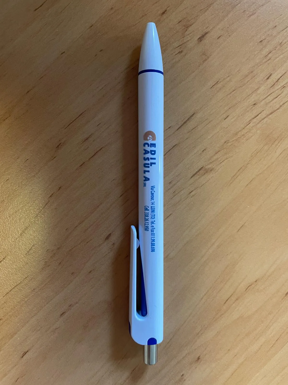 Penna bianca a scatto con logo e recapiti di un'impresa edile stampati in blu